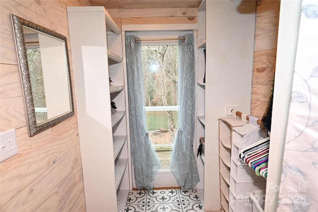 doorway to outside with wooden walls