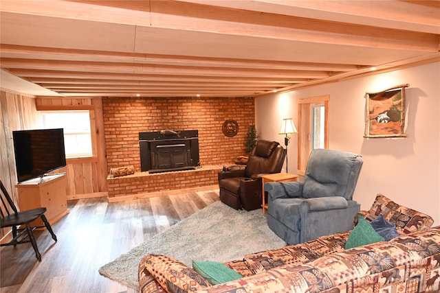 living room featuring beamed ceiling, hardwood / wood-style flooring, and wooden walls