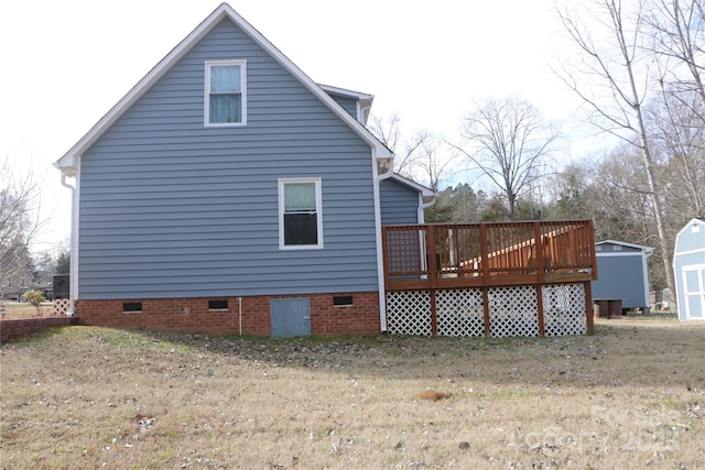 view of side of home featuring a wooden deck, a yard, and a storage shed