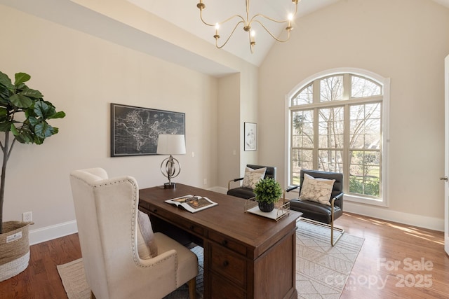 office area featuring high vaulted ceiling, light hardwood / wood-style flooring, and a notable chandelier