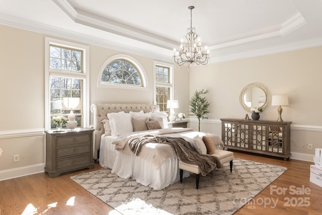 bedroom with a tray ceiling and hardwood / wood-style flooring