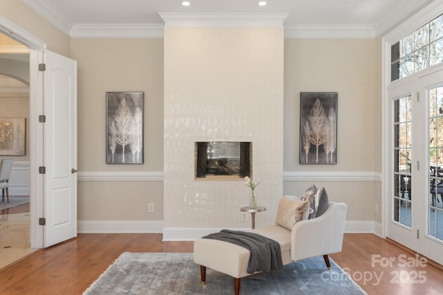 living area featuring ornamental molding and wood-type flooring