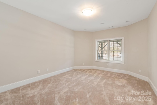 spare room featuring light colored carpet