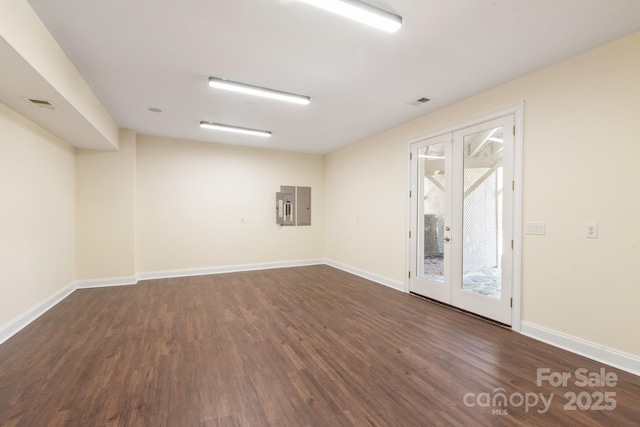 spare room featuring electric panel, dark hardwood / wood-style flooring, and french doors