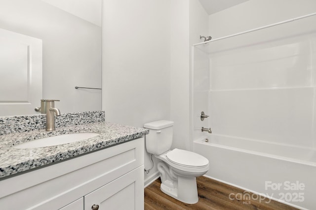 full bathroom with vanity, wood-type flooring, toilet, and washtub / shower combination