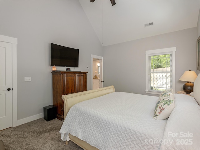 bedroom with ceiling fan, high vaulted ceiling, light carpet, and ensuite bath