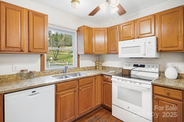 kitchen with sink, dark hardwood / wood-style flooring, light stone counters, ceiling fan, and white appliances