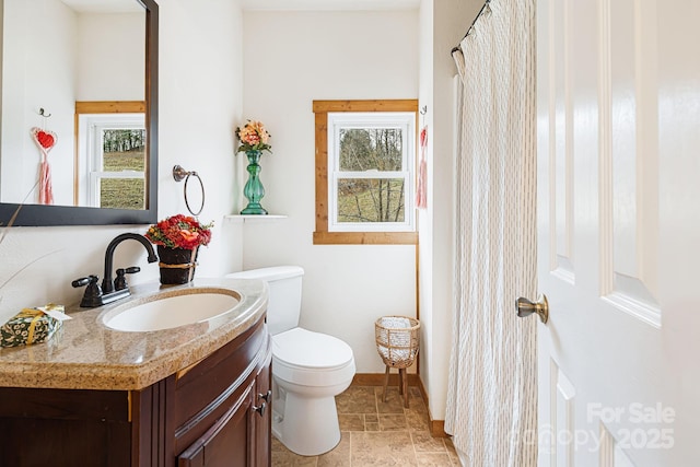 bathroom featuring vanity, a wealth of natural light, and toilet