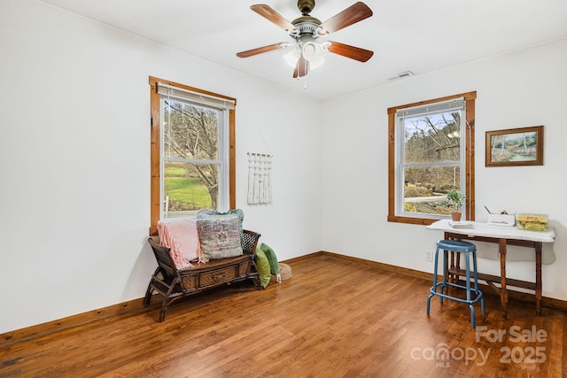 living area featuring wood-type flooring and ceiling fan