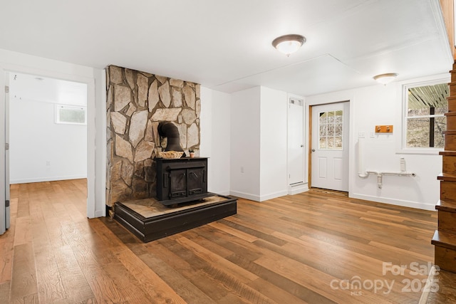 living room featuring wood-type flooring and a wood stove