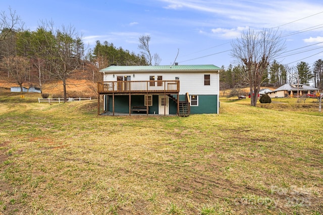 back of house featuring a wooden deck and a lawn