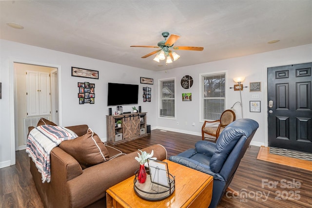 living room with dark wood-type flooring and ceiling fan