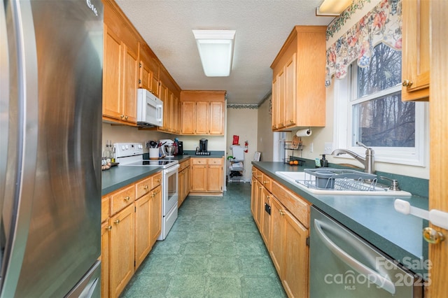 kitchen with sink, stainless steel appliances, and a textured ceiling