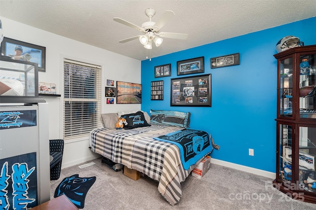 carpeted bedroom featuring a textured ceiling and ceiling fan