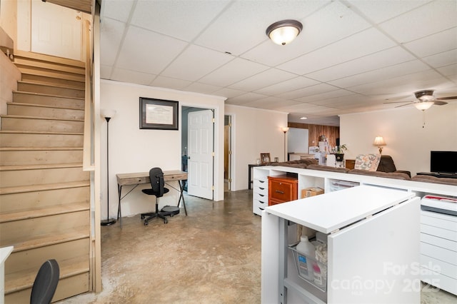 kitchen featuring wooden walls, a paneled ceiling, concrete flooring, and ceiling fan