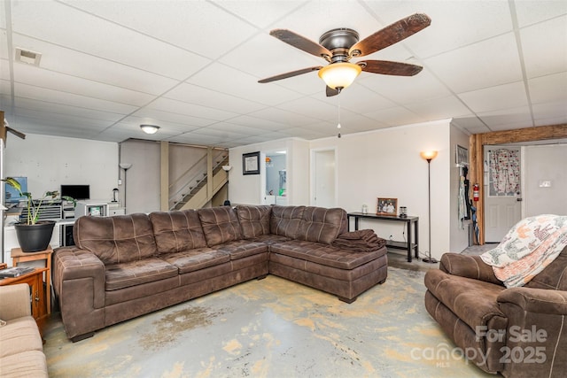 living room featuring a drop ceiling, concrete floors, and ceiling fan