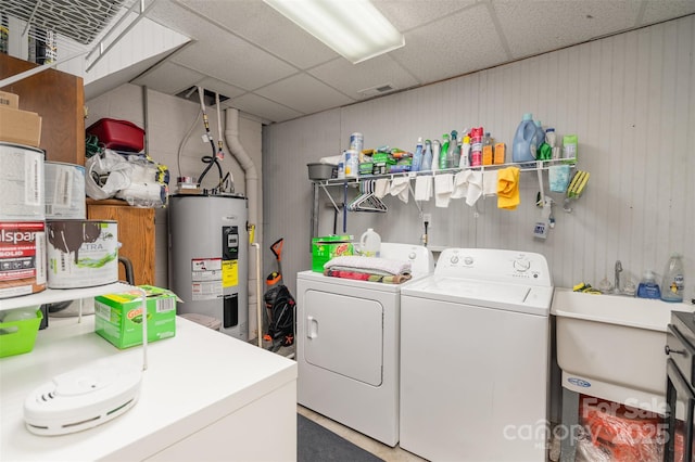 washroom featuring water heater, sink, and washer and dryer