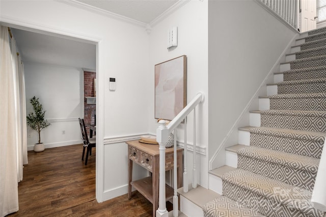 staircase with hardwood / wood-style floors and crown molding