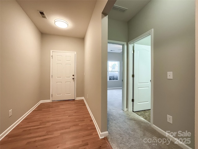 hall with light colored carpet