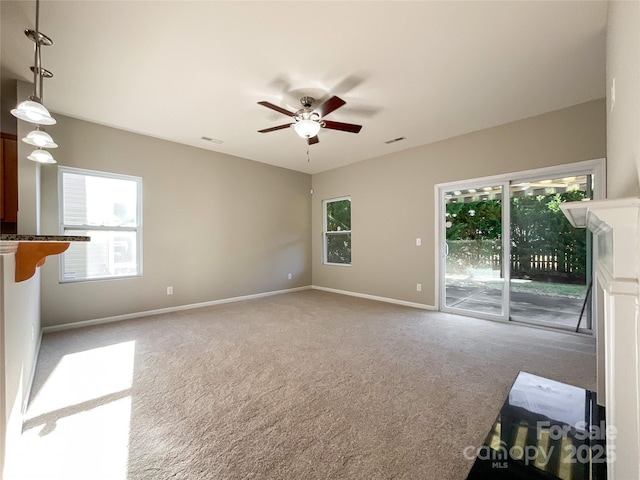 unfurnished living room featuring light colored carpet and ceiling fan