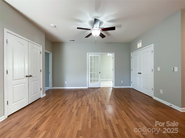 unfurnished bedroom featuring light wood-type flooring, ceiling fan, and french doors