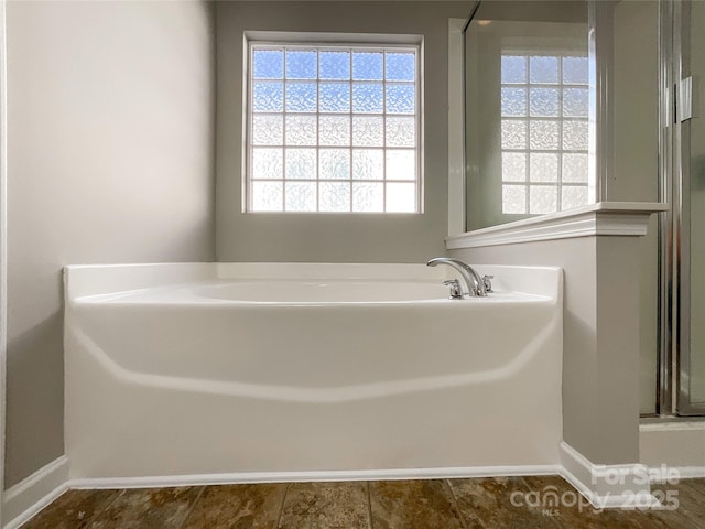 bathroom featuring shower with separate bathtub