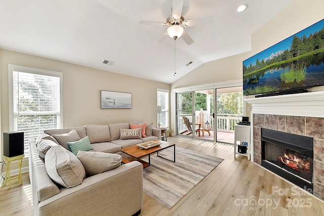 living room with ceiling fan, a healthy amount of sunlight, a fireplace, and light wood-type flooring