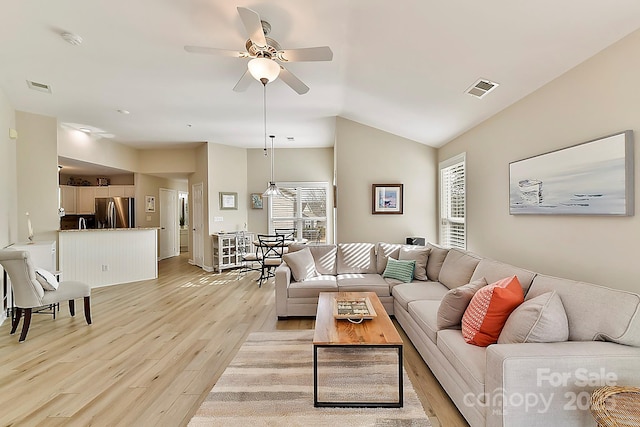 living room featuring ceiling fan, lofted ceiling, and light hardwood / wood-style floors