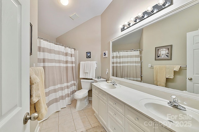 bathroom featuring vanity, vaulted ceiling, tile patterned floors, and toilet