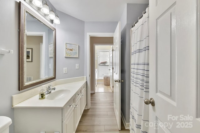 bathroom featuring vanity, toilet, and hardwood / wood-style floors