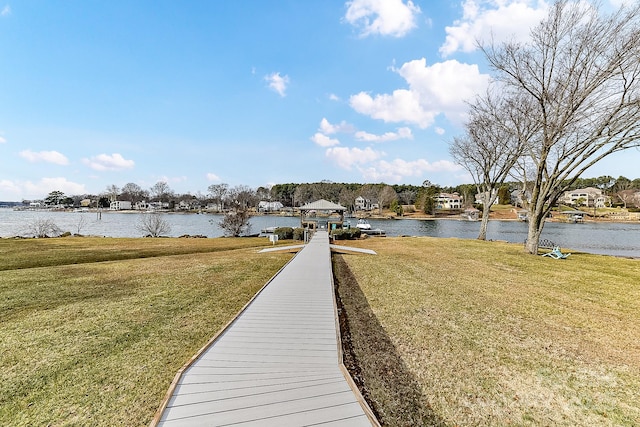 view of dock with a water view and a yard