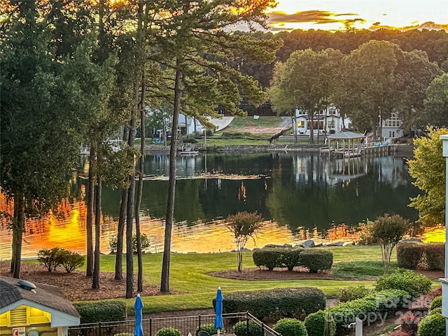 view of community with a lawn and a water view