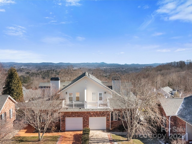 front of property featuring a garage, a balcony, and a mountain view