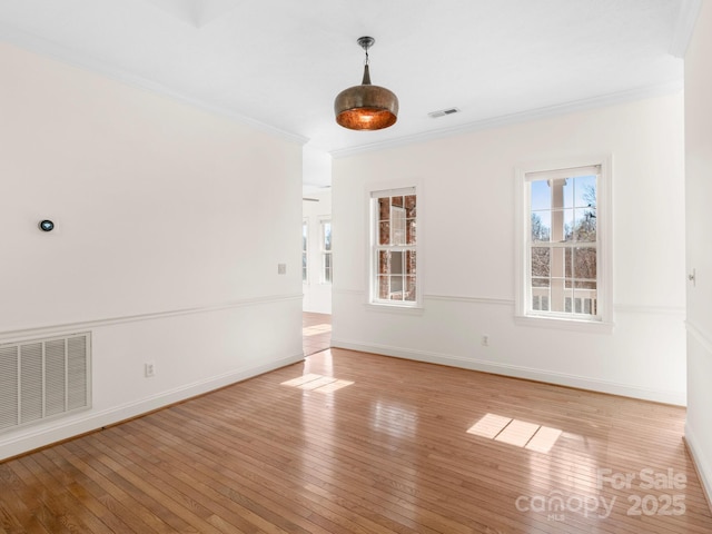 unfurnished room featuring ornamental molding and light hardwood / wood-style flooring