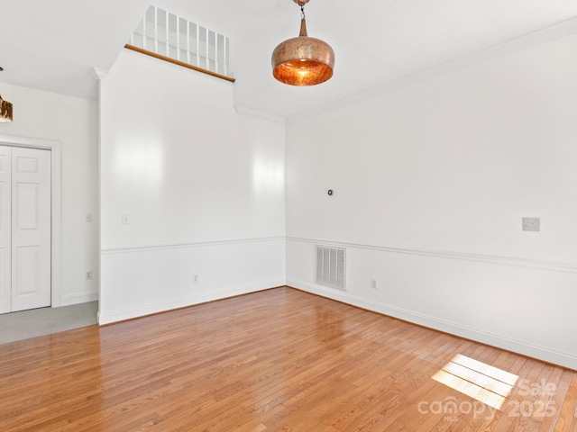 unfurnished room featuring ornamental molding and light hardwood / wood-style flooring