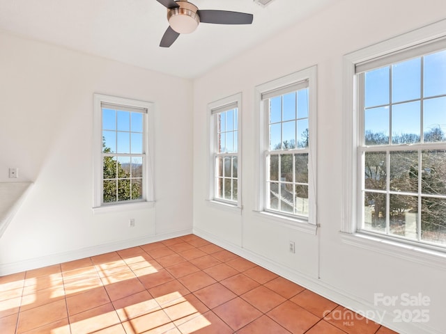 unfurnished sunroom featuring ceiling fan and a healthy amount of sunlight