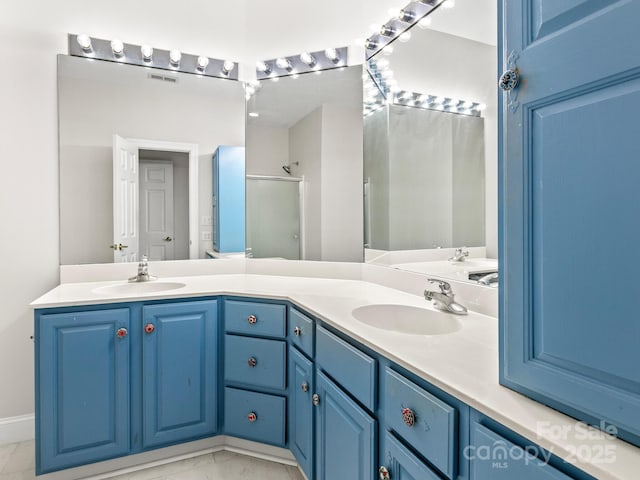 bathroom with vanity and a shower with door