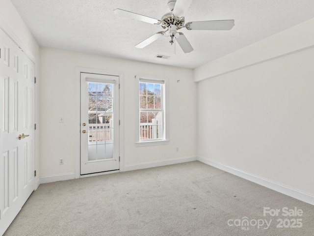 carpeted empty room featuring a textured ceiling and ceiling fan