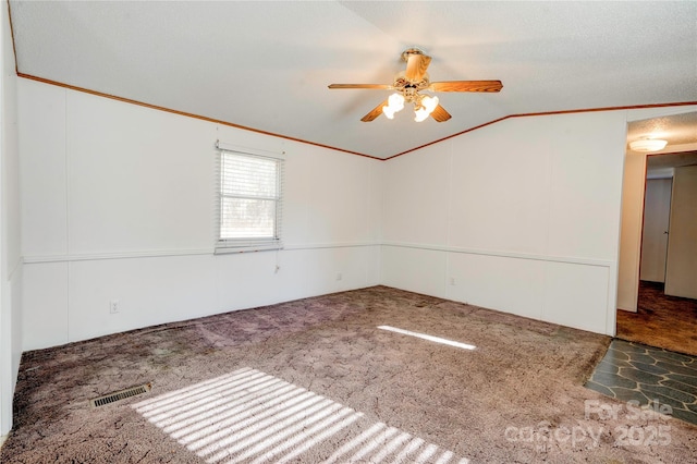 carpeted spare room featuring ceiling fan and vaulted ceiling