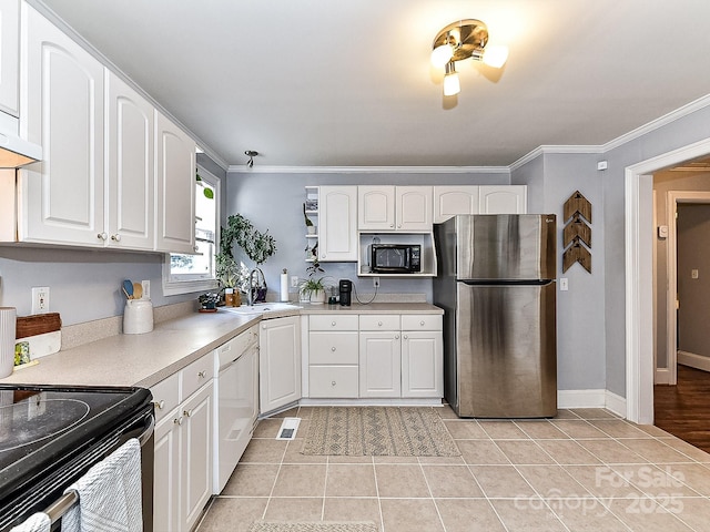 kitchen featuring dishwasher, stainless steel fridge, sink, white cabinetry, and light tile patterned flooring