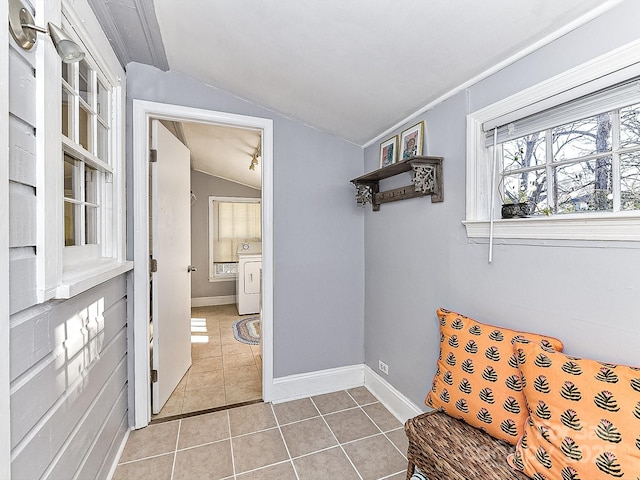 living area with vaulted ceiling, light tile patterned floors, and washer / clothes dryer