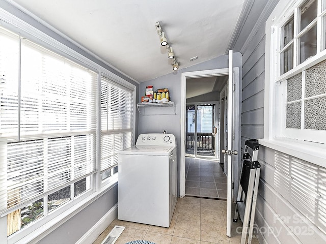 washroom with rail lighting, washer / clothes dryer, plenty of natural light, and light tile patterned flooring