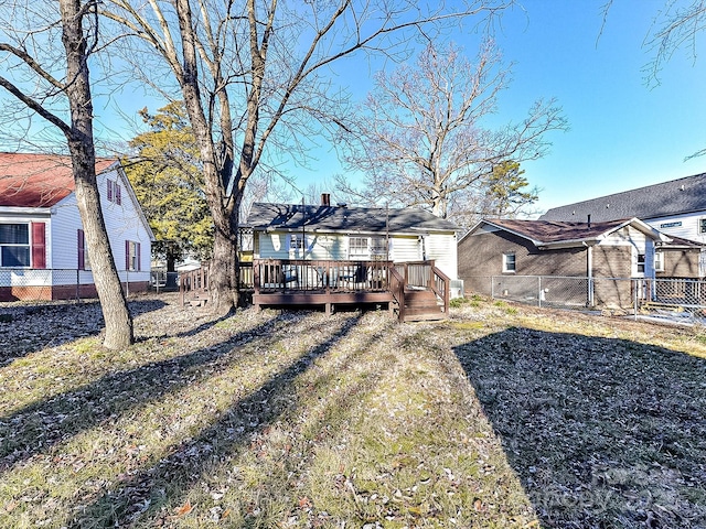 back of house with a deck and a lawn