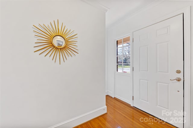 entryway featuring hardwood / wood-style flooring and crown molding