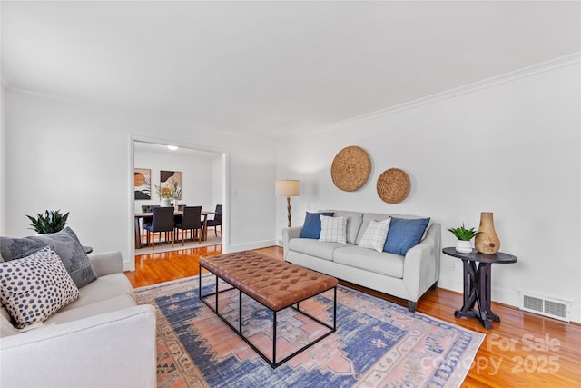 living room featuring hardwood / wood-style flooring and crown molding