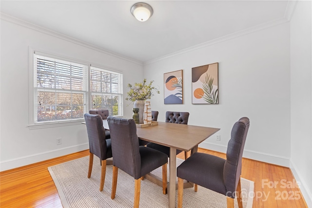 dining room with hardwood / wood-style flooring and ornamental molding