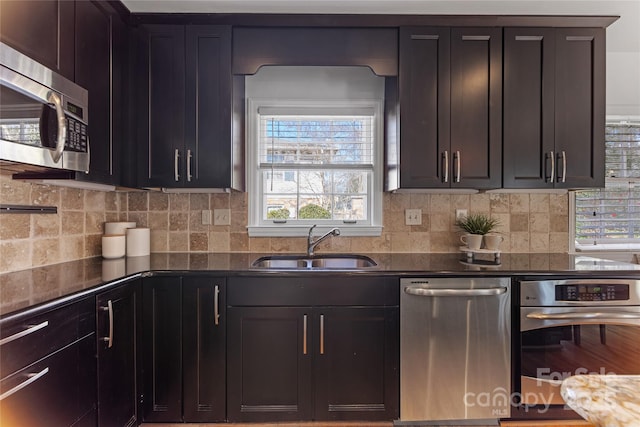 kitchen with sink, decorative backsplash, dark brown cabinets, and appliances with stainless steel finishes