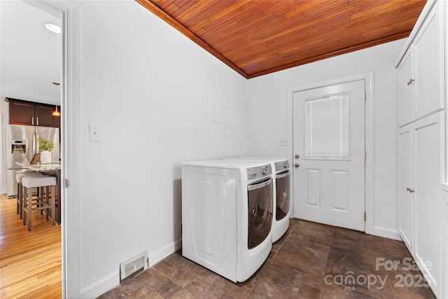 washroom with ornamental molding, washing machine and clothes dryer, and wooden ceiling