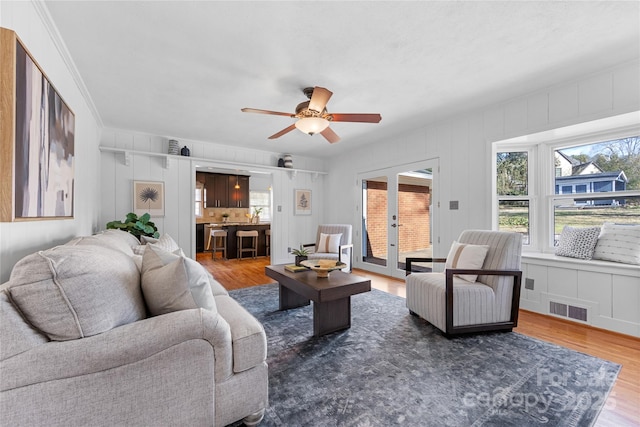 living room with french doors, ceiling fan, and wood-type flooring