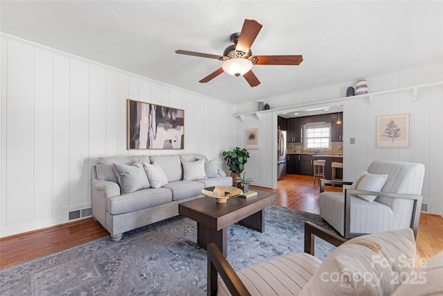 living room featuring sink, dark hardwood / wood-style floors, and ceiling fan